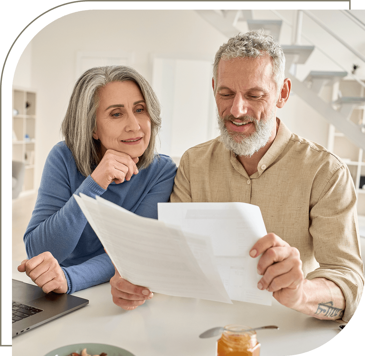 Older couple reviewing paperwork at home.