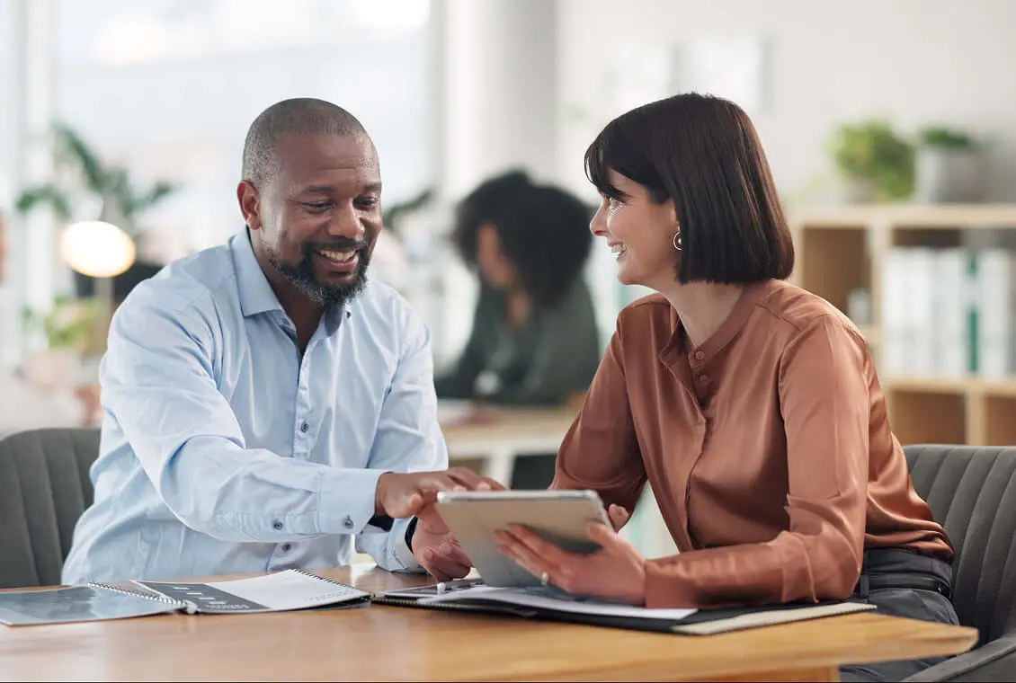 Man and woman discussing over a tablet.